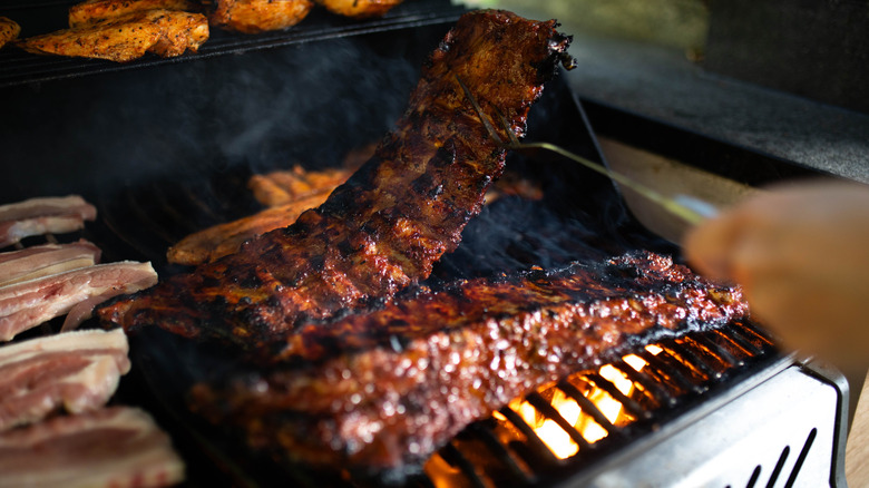 Barbecue ribs covered in sauce on a grill