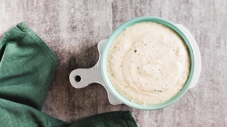 Close up of ranch dressing made with cottage cheese and pickles in a bowl top view