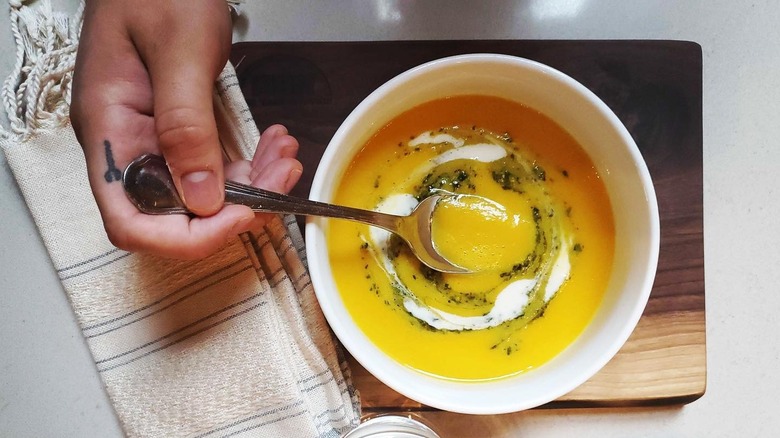 A person taking a spoonful of squash soup from Alma in Minneapolis