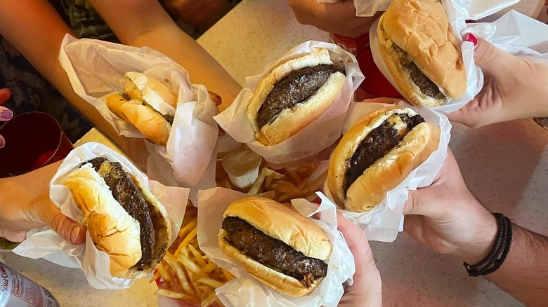 People holding Jucy Lucy hamburgers from Matt's Bar in Minneapolis