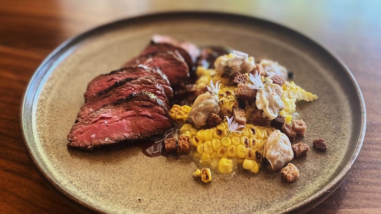 A plate with tenderloin steak and corn from Tilia in Minneapolis