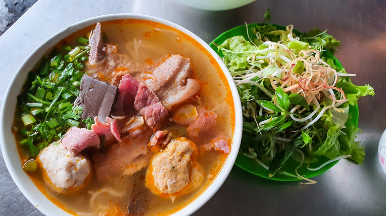 Bún bò Huế in bowl with salad