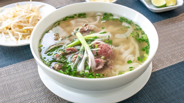 Pho in white bowl with ingredients