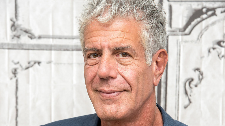 A photo of a serious Anthony Bourdain wearing a suit at an event