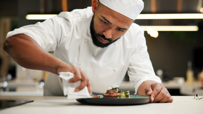 Chef carefully preps a plate before serving