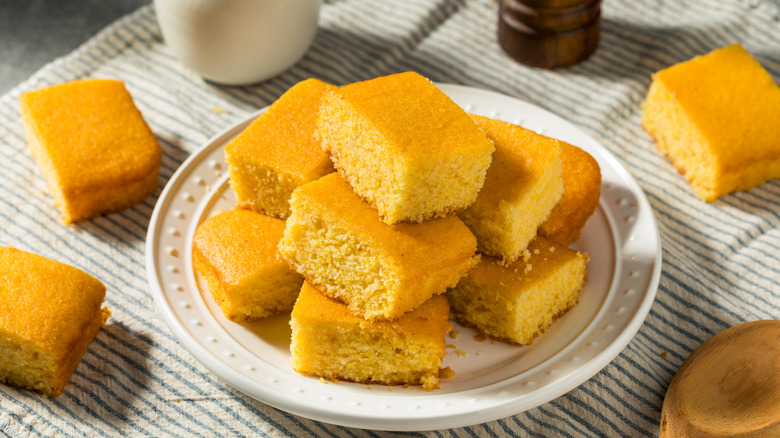 Homemade cornbread stacked on a plate on a table