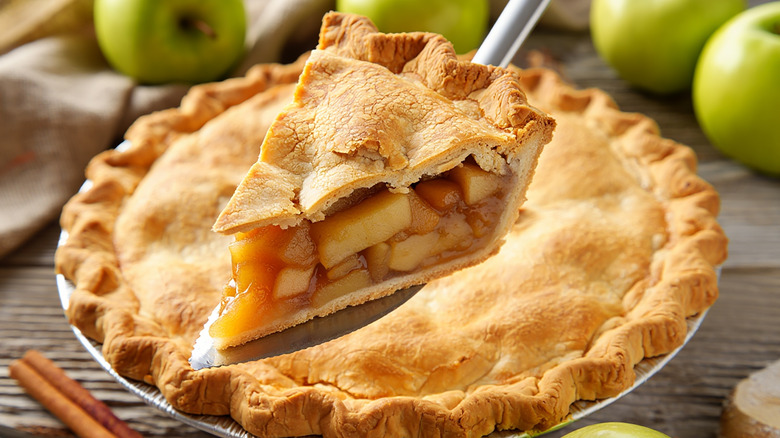a slice of brown apple pie being lifted out