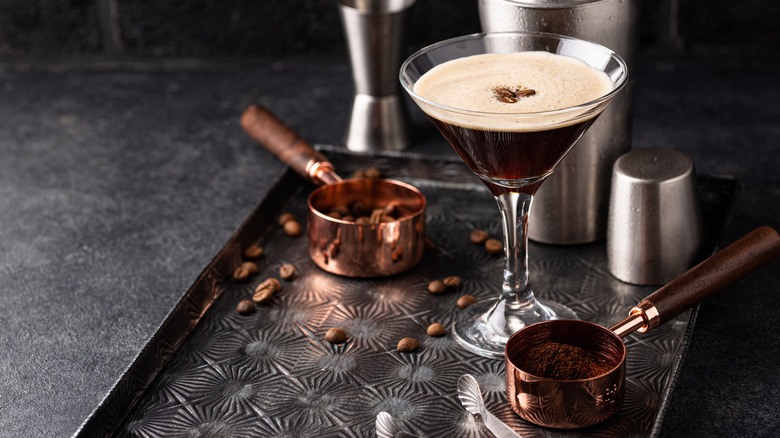 Espresso martini on silver tray with espresso makings.