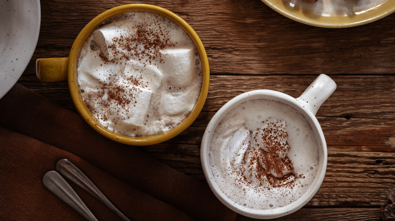 Two mugs of hot chocolate or hot cocoa with marshmallows on top