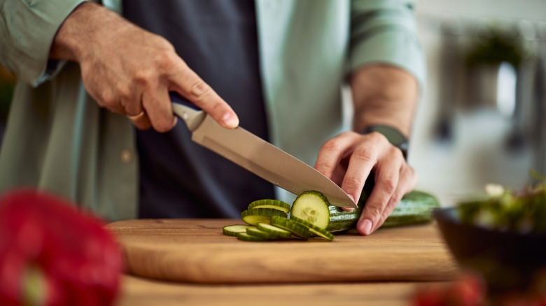 Person holding a knife with the index finger on top