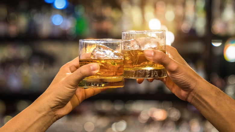 clinking whiskey glasses