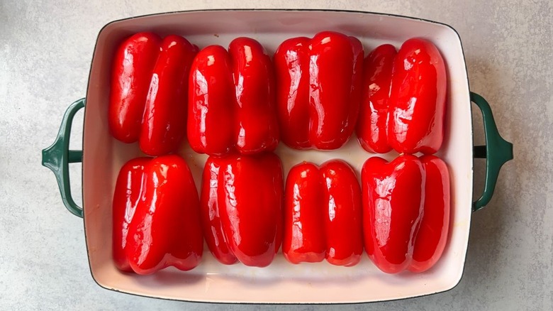 Oiled red bell pepper halves cut-side-down in baking dish