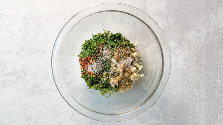 Chimichurri ingredients in glass bowl
