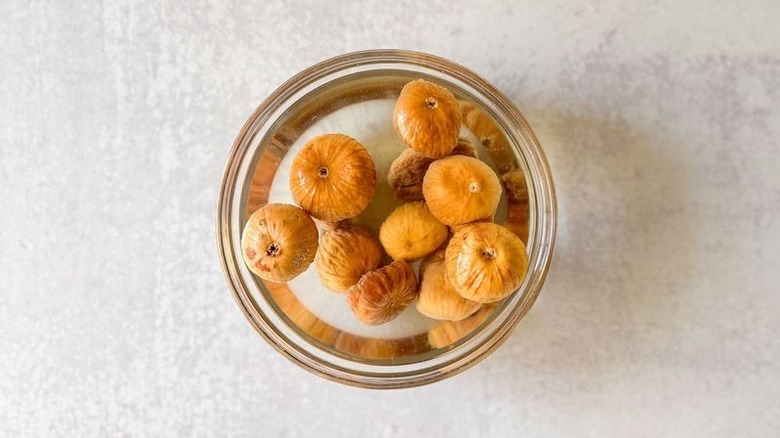 Turkish figs soaking in hot water in glass bowl
