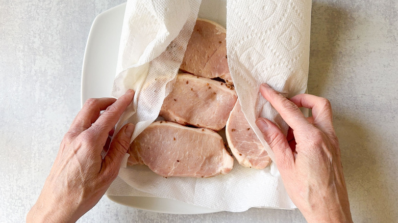 Blotting brined pork chops dry with paper towels