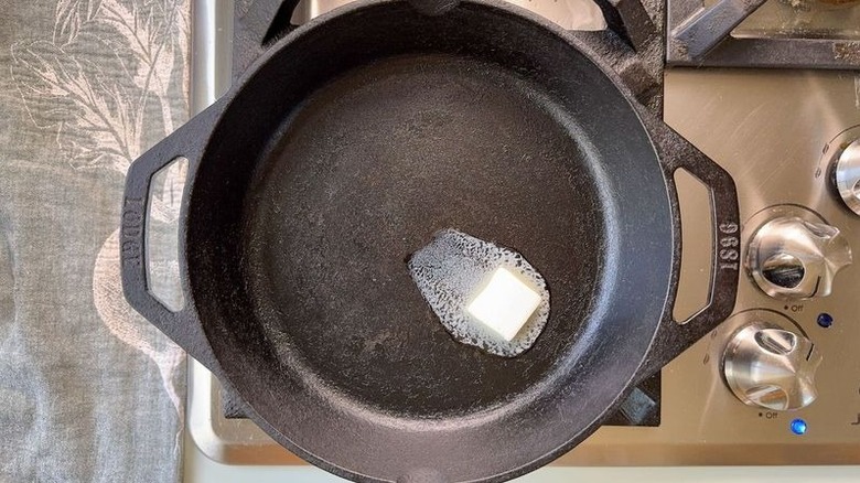 Butter melting in cast iron skillet on stovetop