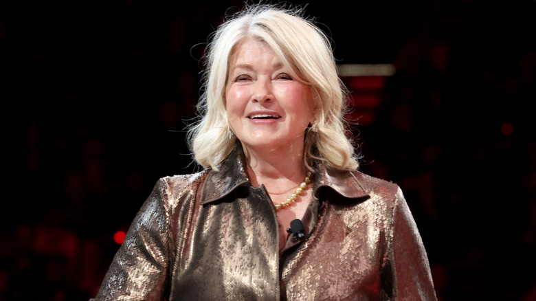 Martha Stewart smiling against a black background.