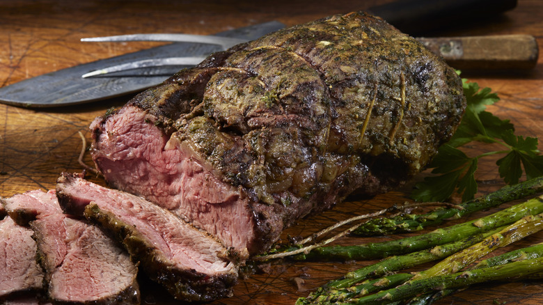 Sliced sirloin roast with vegetable garnishes.