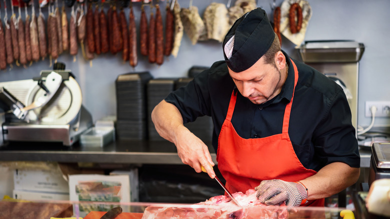 A butcher working in a store.