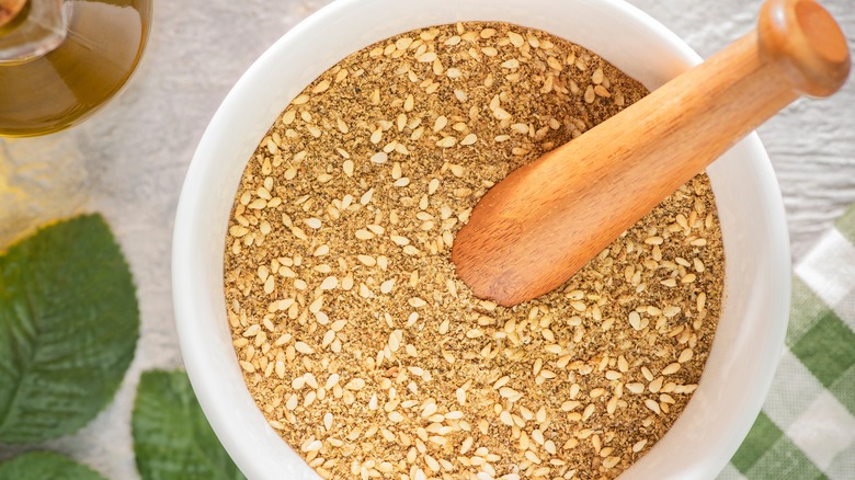 Dukkah seasoning in a white bowl on countertop.