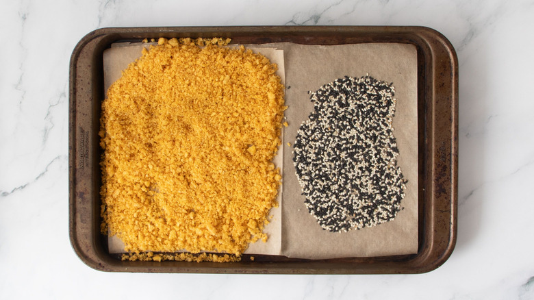 Crushed Funyuns and sesame seeds on baking sheet