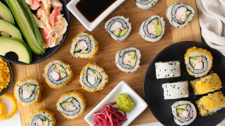 Sliced California roll sushi with various toppings and sauces
