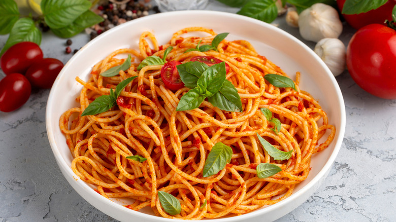 a bowl of spaghetti with tomato sauce and basil