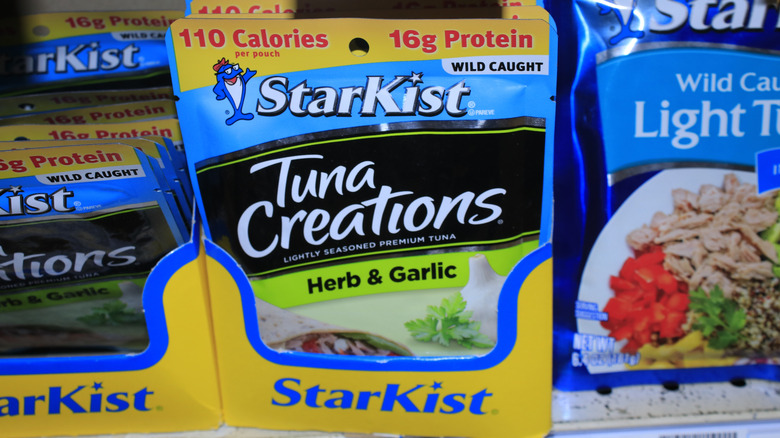 Tuna pouches sit on a grocery store shelf