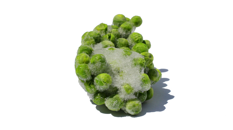 Frozen peas clumped together and covered with ice