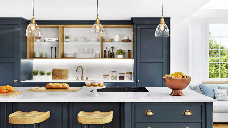 A fairly neutral kitchen has white walls, dark blue cabinets, and gold trim.