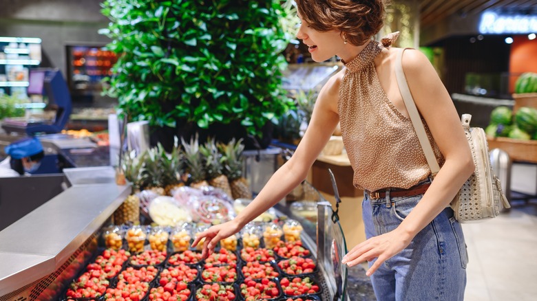 person shopping for strawberries at a store