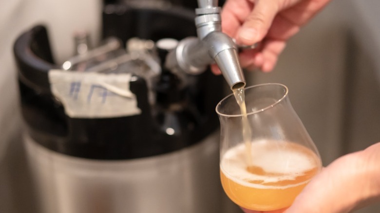 Hand pouring beer from a home keg spout