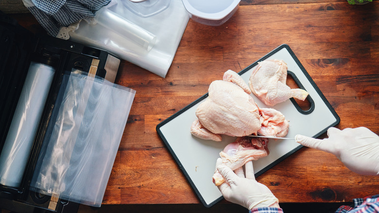 Person cutting a whole chicken into pieces