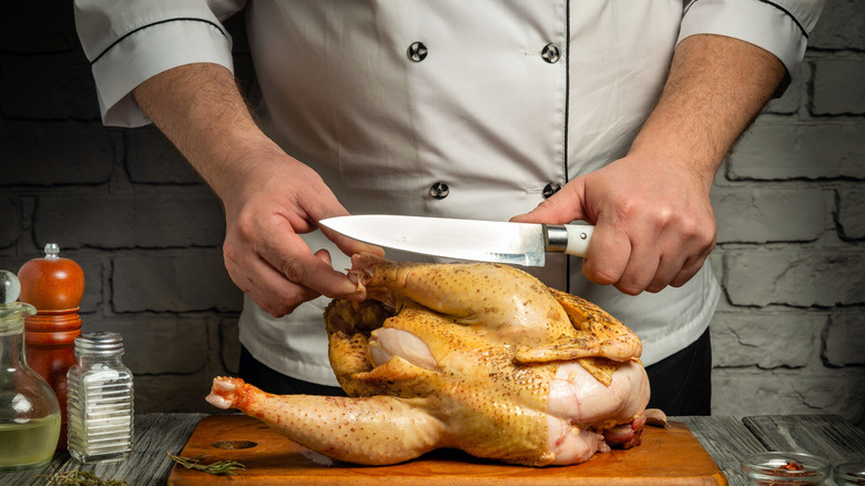 Person getting ready to debone a chicken with a knife