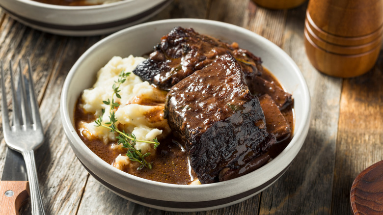A plate of braised short ribs with mashed potatoes and gravy