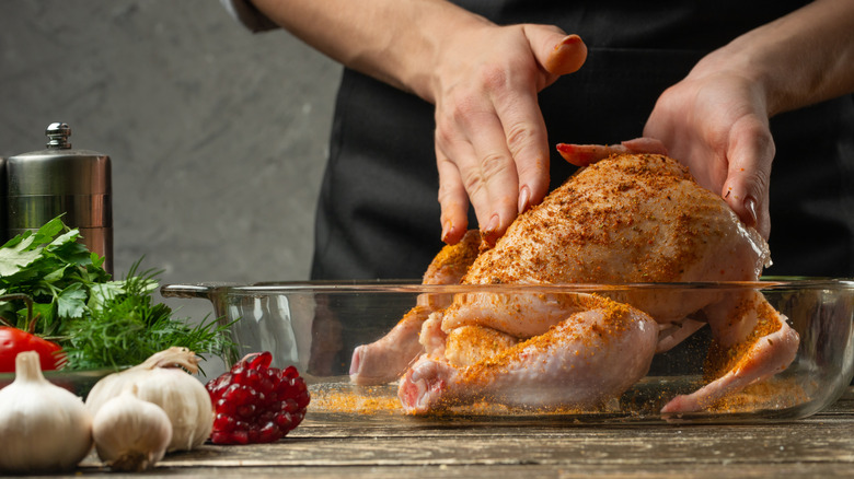 Cook rubbing chicken with spices