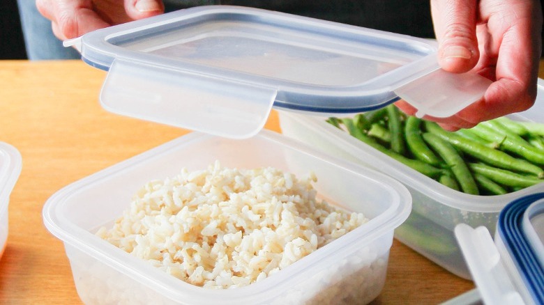 leftover rice in a plastic container with a side of leftover green beans