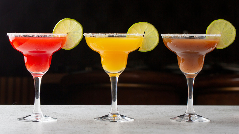 Three different flavors of cocktail, each with a lemon slice