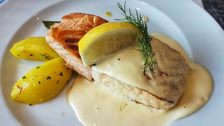 A plate of fish covered in a heavy cream sauce