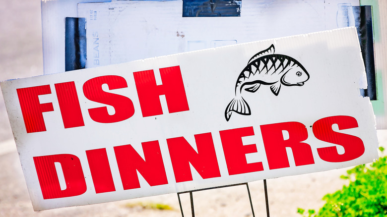 A yard sign that says "Fish dinners"