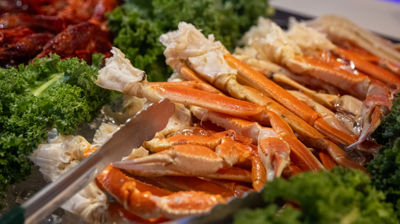 Crab legs on a buffet with tongs
