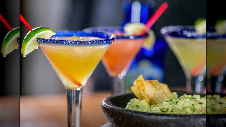 Three Chili's margaritas on a table, next to chips and guacamole