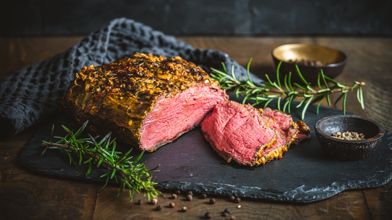 A sliced roast beef on a cutting board
