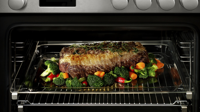 A roast beef in a pan with vegetables