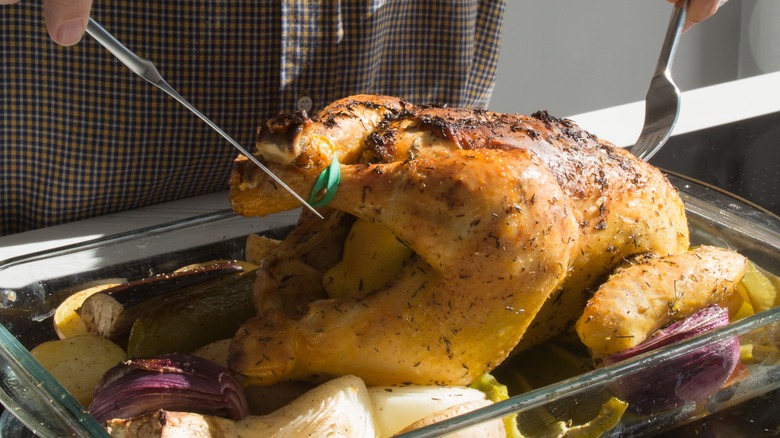 Person turning whole chicken