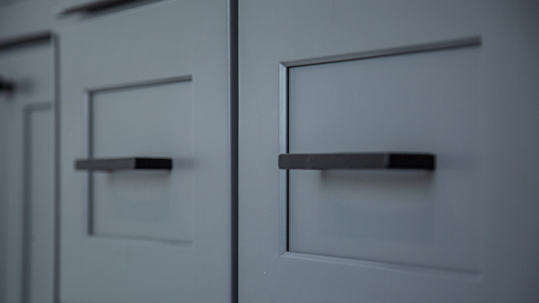 Bar pulls on dark blue drawers.