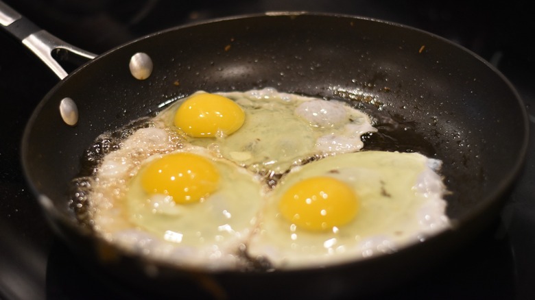 A skillet with bacon grease and fried eggs