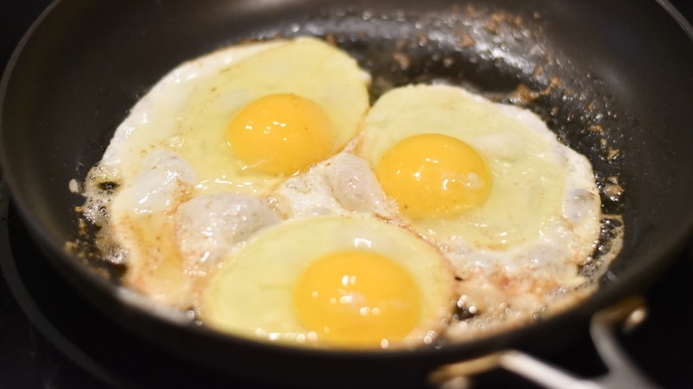 A skillet with melted butter and fried eggs