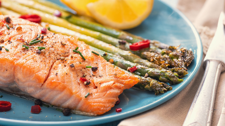 Baked salmon is plated with asparagus.