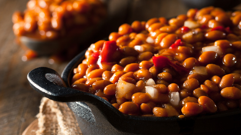 A cast iron skillet filled with baked beans